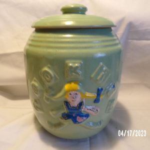 Product Image and Link for Vintage MCCOY Green Cookie Jar Rag Doll Girl Green Crock Stoneware 9″ Tall